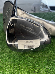 Golf club head with a visible brand label on a grassy background